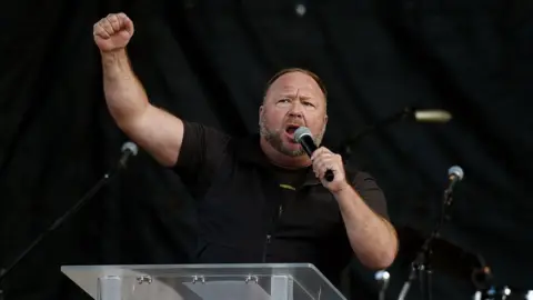 Getty Images Alex Jones speaks to Trump supporters at a rally in December 2020