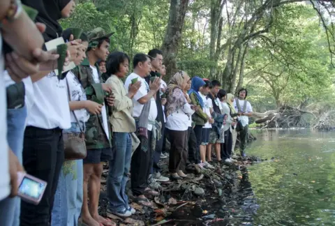 Rukkhaoyai People pray at a riverside memorial service for lost elephants