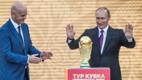 AFP Vladimir Putin with the 2018 World Cup trophy