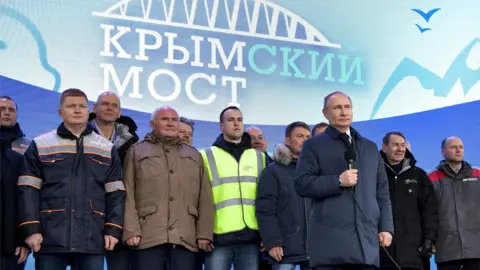 Getty Images Russian President Vladimir Putin speaks to workers after riding a train connecting the Crimea to mainland Russia in Taman on December 23, 2019