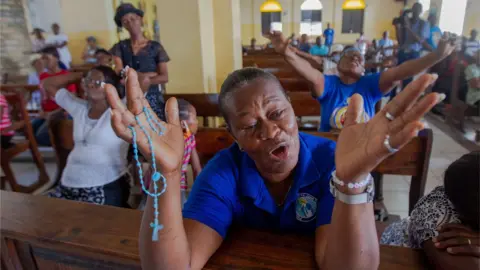 Reuters Parishioners pray in Saint Antoine Church, where Father Michel Briand, one of the religious kidnapped days ago, worked for decades, in Port-au-Prince, Haiti, on 23 April