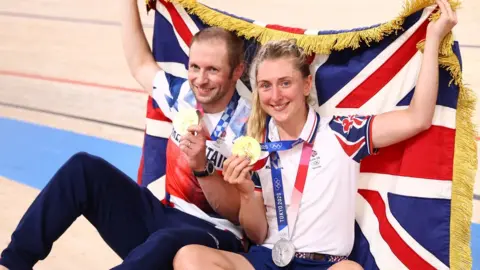 Reuters Jason Kenny and his wife Laura of Britain pose with their medals and a British flag
