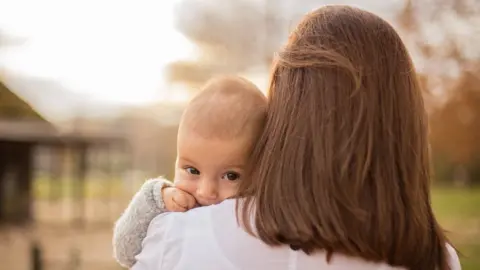 Getty Images Woman holding baby