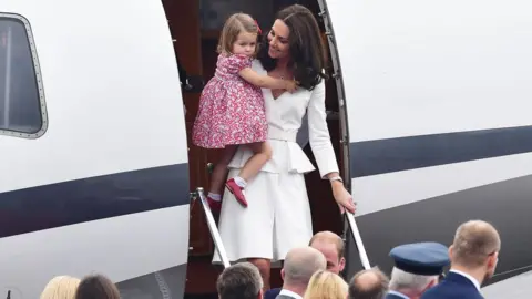 PA The Duchess of Cambridge carries Princess Charlotte off the plane at Warsaw