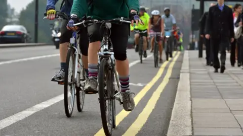 BBC People cycling down a road in London