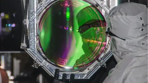 Ligo scientists fitting a mirror
