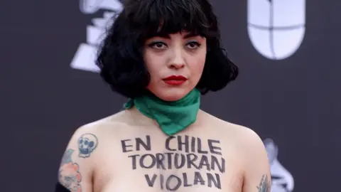 Getty Images Mon Laferte pictured with the words "in Chile they torture, rape and kill".