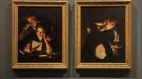 Oliver Taylor/Derby Museums A Girl Reading A Letter With An Old Man Reading Over Her Shoulder and Two Boys Fighting Over A Bladder