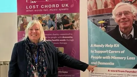 Isobel Garnett Chris Suich standing next to a Bob's Brainwaves sign