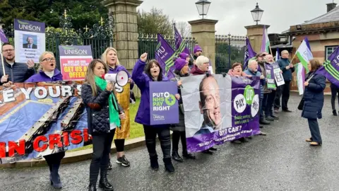 PA Media Protestors gathered outside Hillsborough Castle