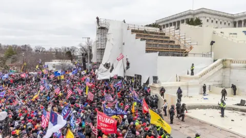 Getty Images Protesters climbed the bleachers that were erected for Biden's inauguration
