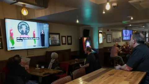 People watching Mark Drakeford's announcement at Potters in Newport