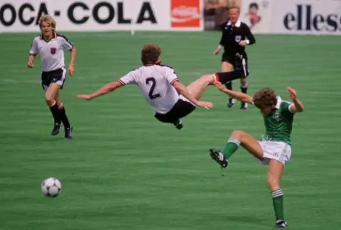 Alamy Norman Whiteside challenges an Austrian opponent