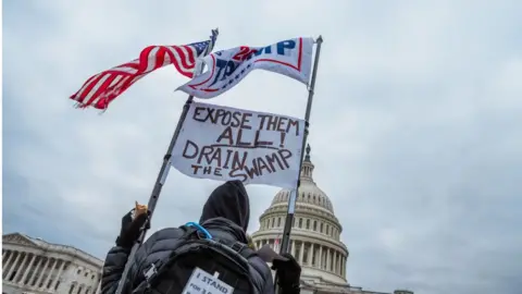 Getty Images Trump supporter holds signs in front of Capitol