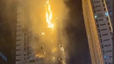 Burning debris falls from apartment tower