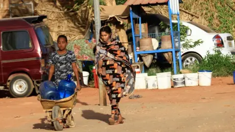 Reuters People look for water during clashes between the paramilitary Rapid Support Forces and the army in Khartoum North, Sudan - 20 April 2023