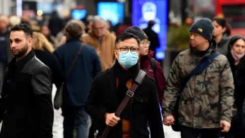 Reuters A shopper wearing a protective face mask walks on Oxford Street, as rules on wearing face coverings in some settings in England are relaxed, amid the spread of the coronavirus disease (COVID-19) pandemic, in London