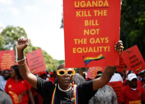 AFP Uganda's queer activist Papa De raises a fist outside the Uganda High Commission during a picket against the country's anti-homosexuality bill in Pretoria on April 4, 2023.