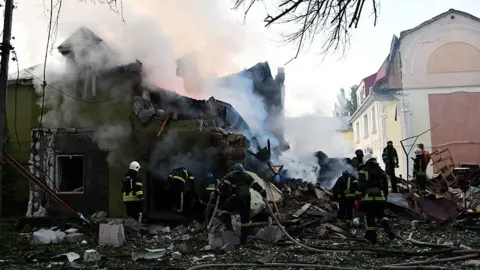 STATE EMERGENCY SERVICE OF UKRAINE Firefighters work at a site of a residential building damaged by a Russian military strike