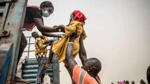Getty Images A child is loaded into a truck taking people fleeing Sudan's war from Joda, on the Sudanese border, to Renk in South Sudan