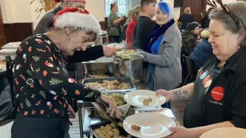 BBC Storehouse foodbank with volunteers serving food to customers