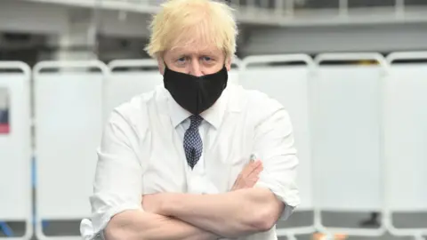 Getty Images Boris Johnson wears a face mask while visiting a Vaccination Centre at the Business Design Centre in Islington on May 18, 2021