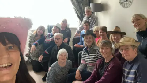 Brain Tumour Research Group of people wearing different hats looking at camera