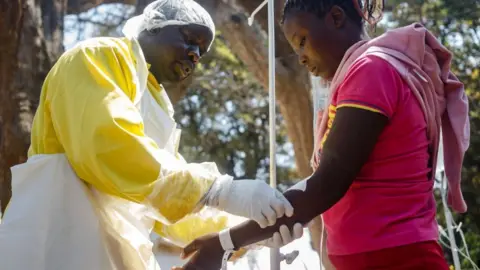 AFP A nurse takes care of cholera patients during a visit of Zimbabwe Minister of Health,