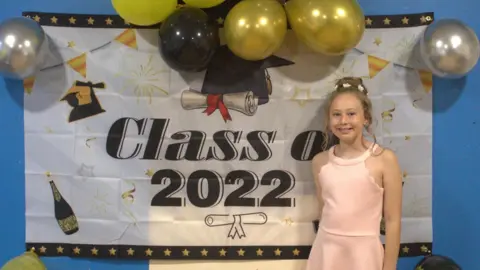 Young girl celebrating graduating primary school