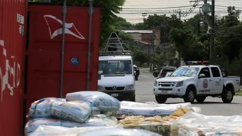 Reuters A police vehicle is seen near a container where the authorities found decomposed bodies inside a fertiliser shipment