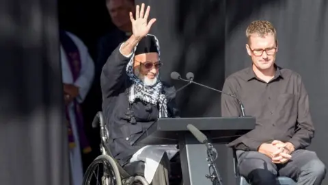 EPA Farid Ahmed, a survicor of the Christchurch shooting, waving to the crowd at the remembrance service on March 29