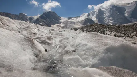 Reuters Meltwater flows on the ice of the Pers Glacier in front of Mount Piz Palue near the Alpine resort of Pontresina, Switzerland