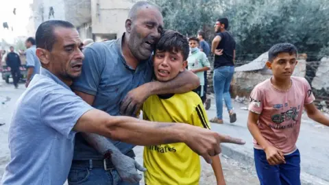 Reuters Palestinians react after an Israeli air strike on Rafah, Gaza (17/10/23)