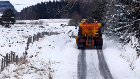 PA Media A gritting lorry on a snow-covered road in Perthshire