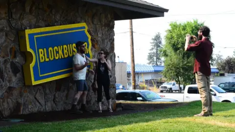 BBC Tourists take pictures in front of Blockbuster sign