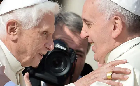 Getty Images Pope Emeritus Benedict XVI is welcomed by Pope Francis at St Peter's Square, Vatican, 2014