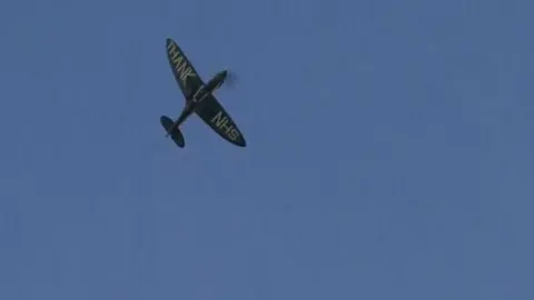 A World War Two Spitfire plane flies over hospitals in Cambridge