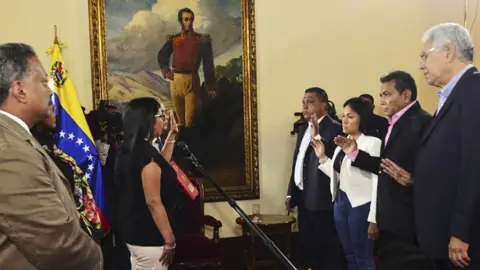 Getty Images Venezuelan Constituent Assembly President Delcy Rodriguez (left) swears in four opposition governors in Caracas, 23 October 2017