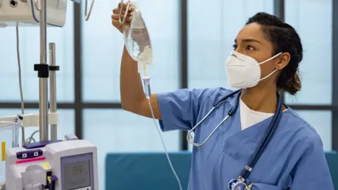 Getty Creative / andresr Nurse at the hospital putting an IV Drip on a patient
