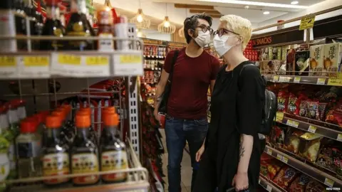 Reuters Customers wearing masks in shops in London