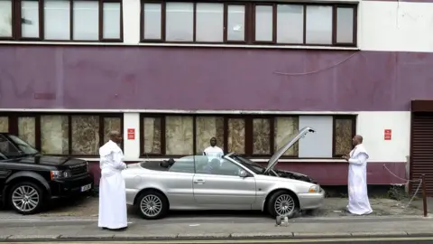 Simn Dawson / Reuters Worshippers bless a vehicle