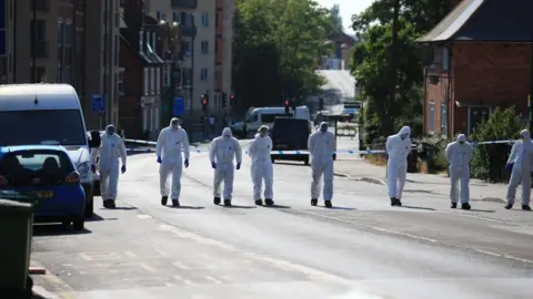 EPA-EFE/REX/Shutterstock A row of forensic investigators walking up a road in Nottingham.