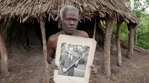 Reuters Village elder from Tanna island holds a picture of Britain's Prince Philip where he is worshipped in Yaohnanen, Vanuatu 6 May 2017