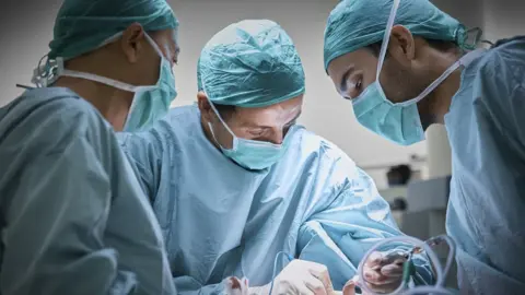 Getty Images Doctors in an operating theatre