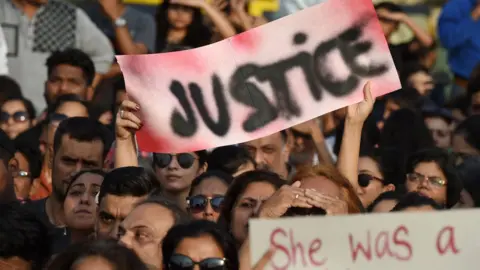 Getty Images Indian demonstrators hold a "justice" placard during a protest in support of rape victims.