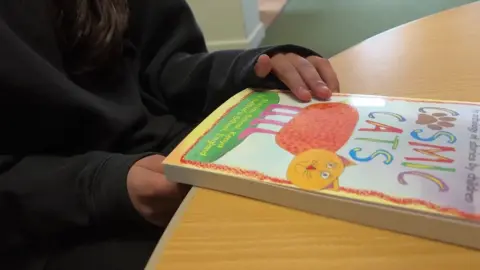 A child with the Cosmic Cats book