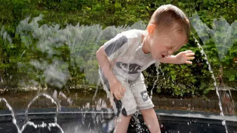 PA Media A little boy laying in a fountain