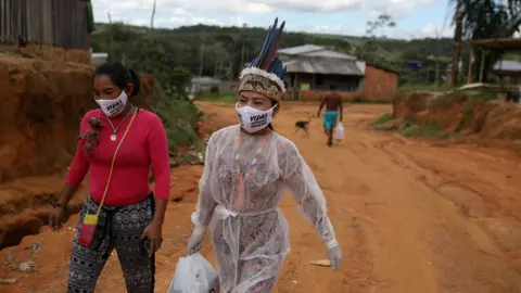 Reuters Vanderlecia and a friend walk along a road in Parque das Trios