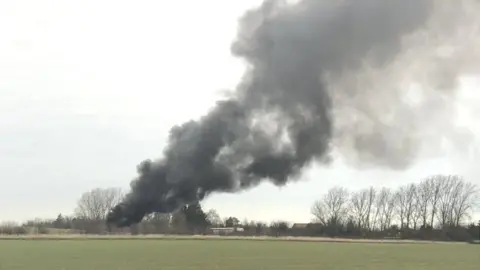 Twitter/mihail66129953 The HGV fire, south of Huntingdon in Cambridgeshire, has created a large plume of black smoke.