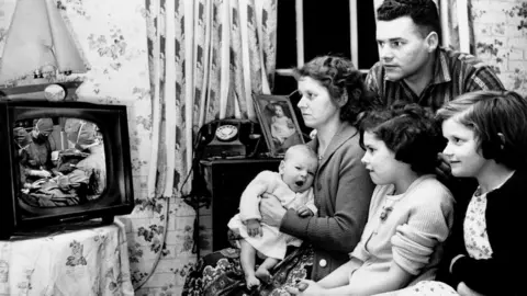 Getty Images The Freeman family watches the Caesarean birth of Mark Freeman on a B.B.C. documentary on television 1936